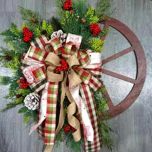Detail of Christmas wreath with pine cones berries and rustic wooden wheel on wood background