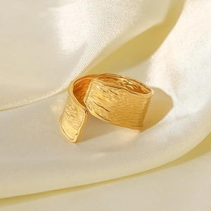 Close-up of 18K gold plated stainless steel ring with wrinkled texture on cream silk