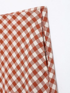 Detailed macro view of an orange gingham skirt featuring a seamless side hidden zipper closure