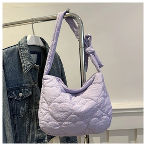 Detail of light purple quilted heart pattern tote bag with knotted shoulder strap