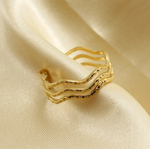 Détail de la bague vague en acier inoxydable doré 18 carats avec texture martelée sur soie