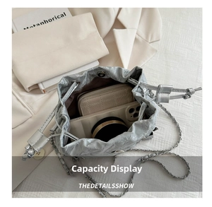 Top view of silver drawstring bucket bag showing spacious interior with phone and wallet