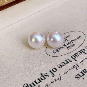 Macro detail of high-luster white pearls with golden S925 silver needles on vintage fabric