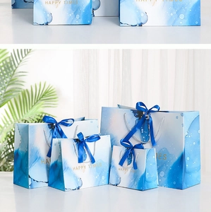 Blue marble ink gift bag set with dark blue ribbon bows and gold Happy Times text