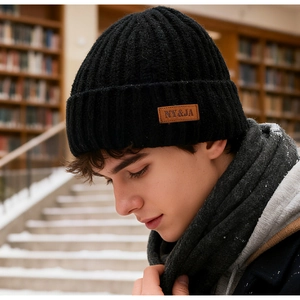 Detail of black winter knit beanie with premium brown leather patch and ribbed texture