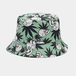 Detail view of mint green bucket hat featuring white skull and green leaf patterns