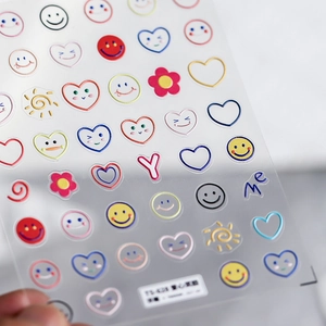 Close-up of 3D embossed nail stickers featuring colorful hearts and smiling faces