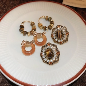 Detail of vintage earring set with pearls and tiger eye stones on a ceramic plate