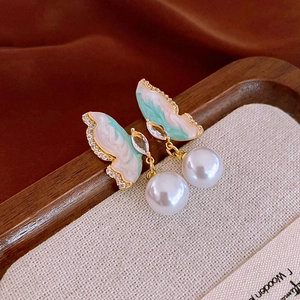 Detail of green enamel butterfly earring with sparkling zircon and round white pearl