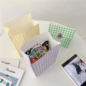 Close-up of colorful checkered paper gift bags in yellow, purple, and green with cute stickers