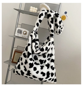 Close-up of soft cow print faux fur tote bag hanging on a minimalist metal grid