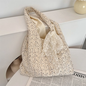 Close-up of beige canvas floral tote bag with lace bow detail and high capacity design