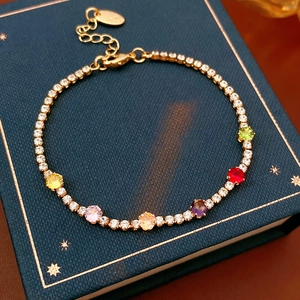 Detail of vintage gold plated tennis bracelet with colorful round zircons and lobster clasp
