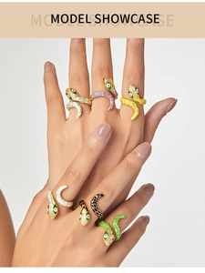 Detailed view of colorful enamel snake rings with zircon accents on a model's hand