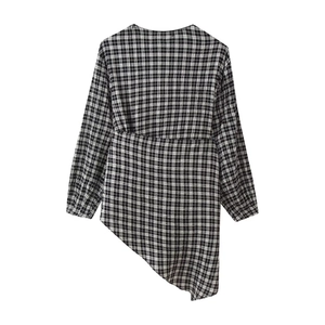Détail de la chemise à manches longues à carreaux noir et blanc avec ourlet asymétrique