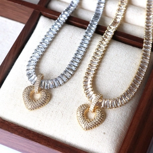 Close-up of gold and silver heart pendants on sparkling cubic zirconia necklaces