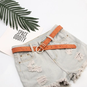 Brown nubuck faux leather belt for women with a round gold buckle on denim shorts
