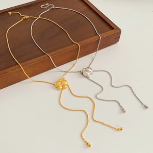 Dettaglio di collane a fiore in oro e argento con zirconi su una catena a serpente