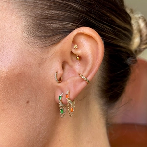 Detailed macro view of S925 silver gold-plated fringe earrings with emerald cut zircon