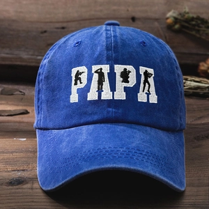 Vintage blue washed denim baseball cap with PAPA embroidery on dark wooden background