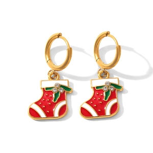 Détail de boucles d'oreilles créoles dorées avec pendentifs chaussettes de Noël rouges