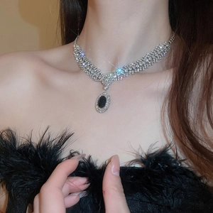 Close-up of vintage silver necklace with black oval gemstone and sparkling multi-layer zircons