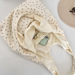 Detailed interior of a beige corduroy floral tote bag showing the zipper pocket and capacity