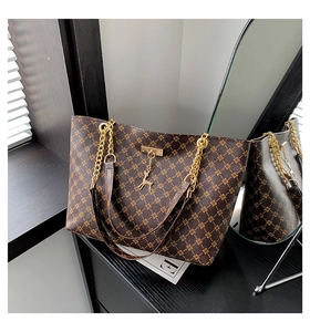 Dettaglio della borsa tote monogramma con catena dorata e ciondolo a forma di cervo