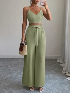 Dettaglio del set in lino verde salvia con top a v e pantaloni a vita alta stile paperbag