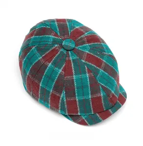 Detailed top view of a classic red and green plaid beret hat with a central button