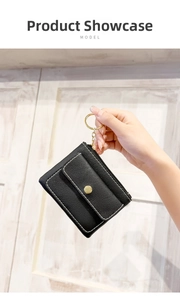 Detail of black lychee leather coin purse with contrast stitching and gold key ring