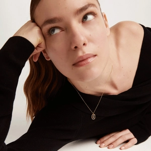 Detail of 18K gold plated S925 silver necklace with textured oval letter C pendant