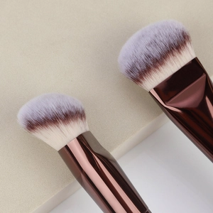 Detailed macro of dual-ended makeup brush with gradient synthetic bristles and rose gold tube