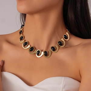 Detail of vintage gold U-shaped link necklace with black oval enamel insets on model