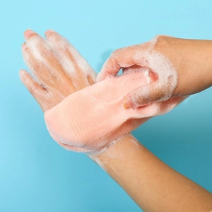 Close-up of pink 6-layer foaming net creating dense lather for facial cleansing