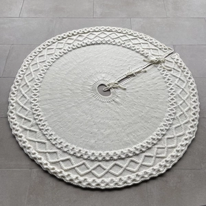 Détail du cache-pied de sapin de Noël crème avec tricot torsadé et liens de fermeture
