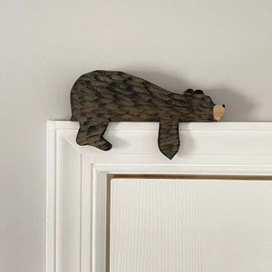 Detailed view of hand-carved wooden brown bear ornament placed on a door frame corner