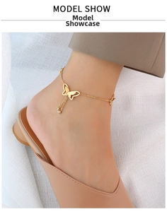 Detail of a 18k gold butterfly anklet with sparkling rhinestone tassels on the ankle