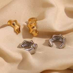 Detailed macro view of bamboo-textured 18K gold and silver plated earrings on silk