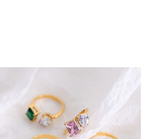 Detail of gold-plated titanium steel rings featuring colorful geometric gemstones