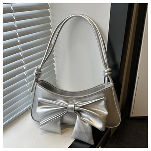 Detailed view of silver metallic crescent bag with large bow and knotted strap details