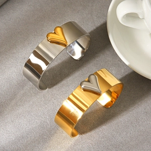 Minimalist wide open cuff bracelets with polished two-tone heart motifs in gold and silver