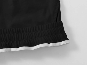 Detail of men's cargo shorts featuring elastic waistband and contrast white piping