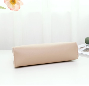 Detailed view of the flat bottom and neat stitching on this beige synthetic leather bag