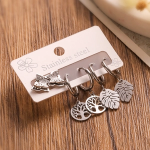 Detail of stainless steel earrings with butterfly and leaf charms on display card