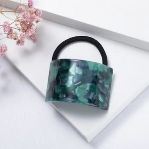 Detailed close-up of dark green marble patterned acetate hair ring with elastic band