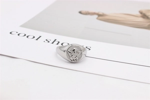 Detailed close-up of a silver cupid angel relief on a vintage steel signet ring
