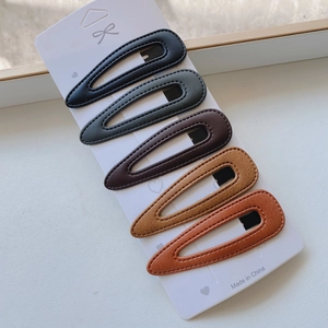 Detail of 5-piece teardrop PU leather hair clips set in assorted autumn neutral colors