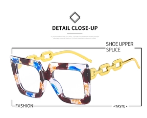 Detail of square glasses featuring multicolor tortoiseshell frame and gold chain temples