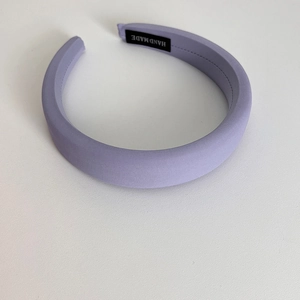 Detail of light purple sponge headband with handmade label and twill fabric texture